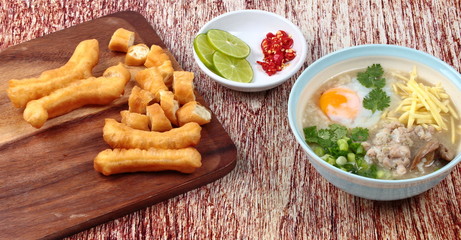 Rice porridge with mined pork and chicken lever served with side dish as Patongko (deep-fried dough stick) and spicy sour filling.