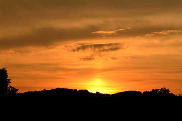 Fototapeta na wymiar Beautiful orange sunset over the silhouetted mountains
