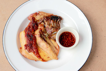 Grilled chicken breast in white dish on wooden table