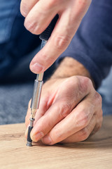 Man assembling furniture at home, hand with screwdriver
