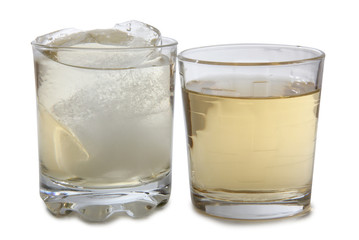 Glass jars with whiskey and ice on white background
