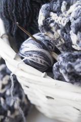 Wicker basket with warm blanket and knitting in it