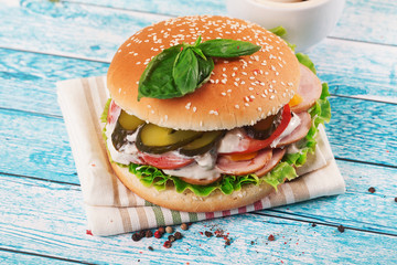 burger with sausage on a wooden table board bright and bun sesame seeds