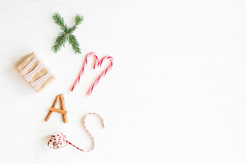 Christmas composition. Christmas candy canes, gift, cinnamon sticks and fir branches. Flat lay, top view