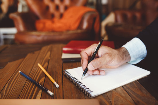 Close-up of hand with pen writing in notebook. Personal and business correspondence, writing letters, exchanging information, communication concept