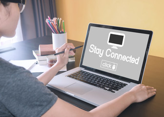 business hand typing on a laptop keyboard with Stay Connected homepage on the computer screen social media technology innovation concept.