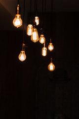 Incandescent lamps in a modern loft. Edison lamp composition on dark background, free space for text or advertisement. Teamwork, idea, creativity, light concept