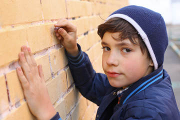 boy in blue hat drawing on the wall