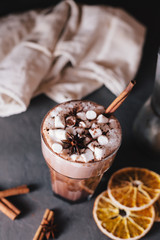 Cocoa or latte or hot chocolate with marshmallow and flavored with cinnamon. On a gray concrete background. Christmas present. Christmas concept. Christmas holiday.