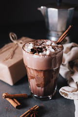 Cocoa or latte or hot chocolate with marshmallow and flavored with cinnamon. On a gray concrete background. Christmas present. Christmas concept. Christmas holiday.
