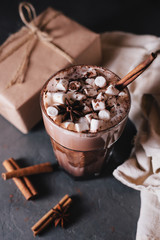 Cocoa or latte or hot chocolate with marshmallow and flavored with cinnamon. On a gray concrete background. Christmas present. Christmas concept. Christmas holiday.