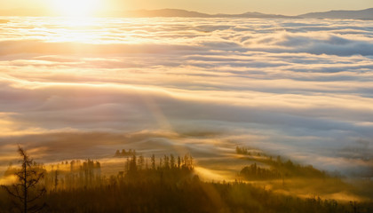 Clouds illuminated by morning sun over valley.