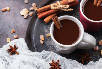 Hot chocolate in mug with spices on grunge dark table