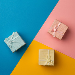 small gift boxes on multicolored paper background