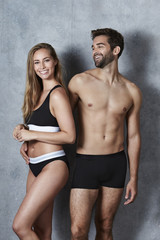 Fototapeta na wymiar Laughing and undressed couple in studio