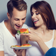 Couple eating crispbread with cheese and tomato