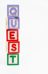 QUEST word wooden block arrange in vertical style on white background and selective focus