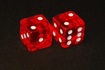two dice on a black desk, result four (4), doublets of two (2)