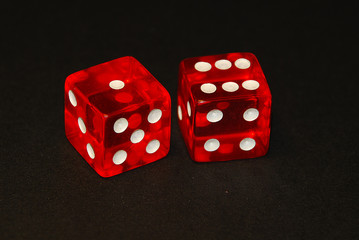 two dice on a black desk, result seven (7), one (1) and six (6)
