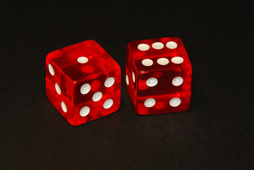 two dice on a black desk, result seven (7), one (1) and six (6)