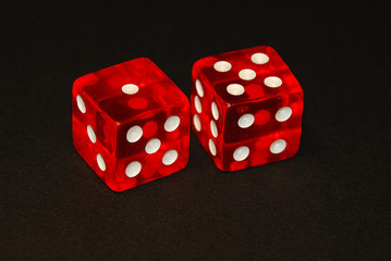 two dice on a black desk, result six (6), one (1) and five (5)