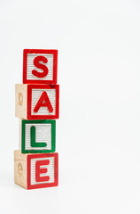 SALE word wooden block arrange in vertical style on white background and selective focus
