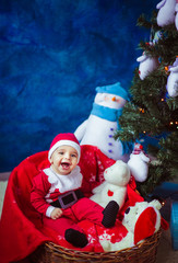 beautiful and smiling baby dressed as Santa Claus