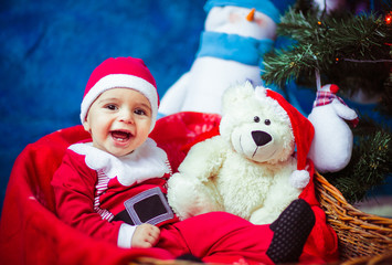 Fototapeta na wymiar beautiful and smiling baby dressed as Santa Claus