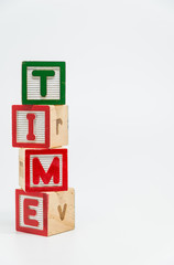 TIME word wooden block arrange in vertical style on white background and selective focus