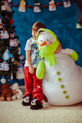 Little boy is hugging a toy snowman