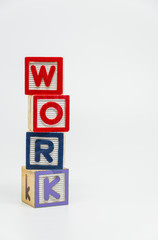 WORK word wooden block arrange in vertical style on white background and selective focus