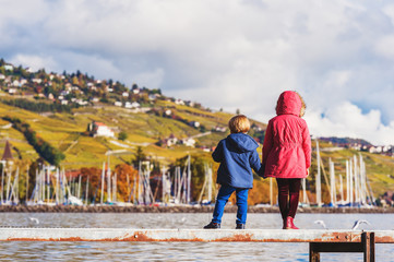 Two kids admiring amazing view of Lake Geneva, Switzerland, back view