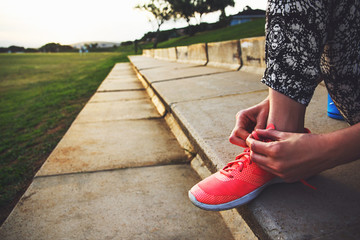 Closeup of tying shoelaces before workout outdoors