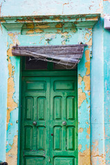 Verwitterte Fassade mit grüner Holztüre auf Gozo, Malta
