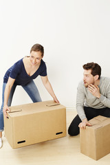 Sleazy dude looking at woman lifting boxes