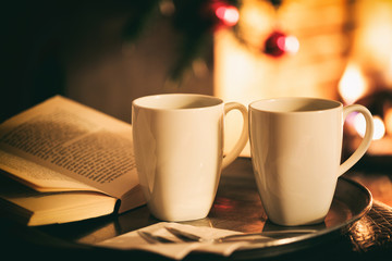 Cups of coffee near a fireplace