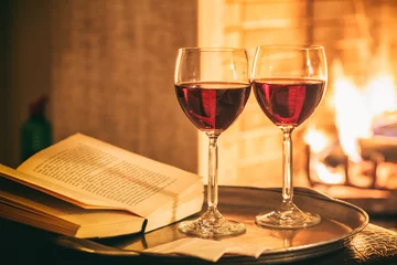 Two glasses of wine near a fireplace