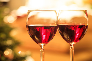 Two glasses of wine near a fireplace