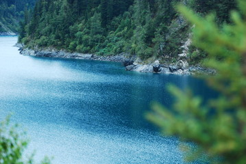 Amazing view of the Five Coloured Pool (the Colorful Pond) with azure crystal clear water among evergreen woods and mountains in Jiuzhaigou nature reserve (Jiuzhai Valley National Park), China.