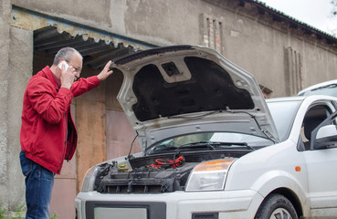 Aged man fixing the car