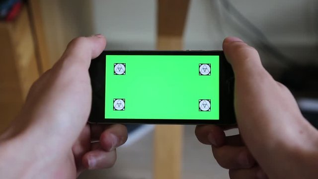 Main et smartphone sur fond vert pour incrustation - Mode paysage