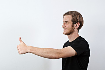 Smiling Young Adult Male in Dark T-Shirt Shows His Thumbs Up