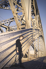 Beautiful girl in style fashion on a background of the bridge