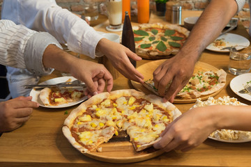 Hand many friends  taking slices of pizza on party table