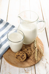 fresh milk in glass jug and glass on wooden background