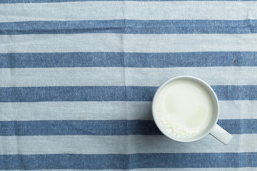 Glass of milk on table on blurred natural background