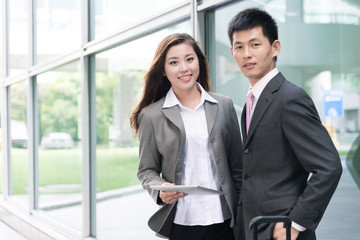 asian beautiful girl and businessman with tablet in modern hall