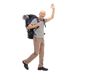 Elderly hiker walking and waving at the camera