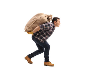 Male agricultural worker carrying burlap sack on his back