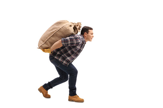 Male agricultural worker carrying burlap sack on his back